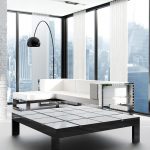 EMDS-Agence Publicitaire Canapé sectionnel blanc moderne et table basse dans un appartement en ville avec des baies vitrées.